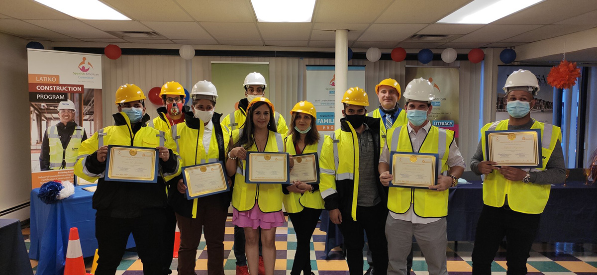 Graduates of the Latino Construction Program proudly hold their certificates of completion