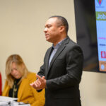 Male speaker delivering a talk to adult learners in a professional setting during a workforce event