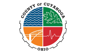 Seal of Cuyahoga County, Ohio, divided into four sections: blue waves, a green leaf, an orange bridge, and a red background with a white heartbeat line, encircled by the countys name.